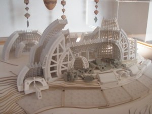 The model shows a completed Arcosanti, but only the gray buildings in the foreground are built at this point.